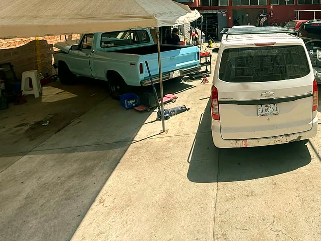 Vehículo en servicio bajo la carpa de trabajo del taller.